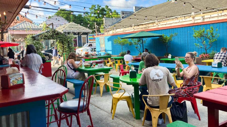 View of the people dining at the colorful outdoor seating area of Dat Dog