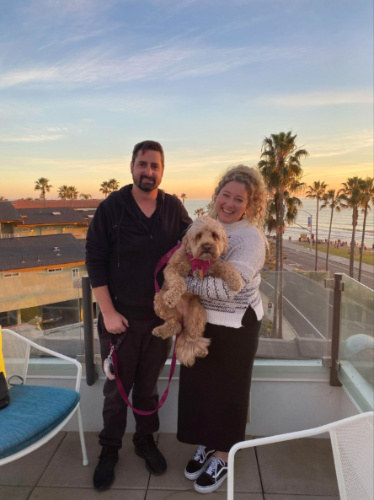 Author Jess carrying her dog while taking a picture with her date at Tower39 Rooftop Lounge
