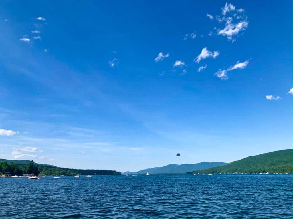 View of the blue sky and water in Lake George with the mountain range view in the distance