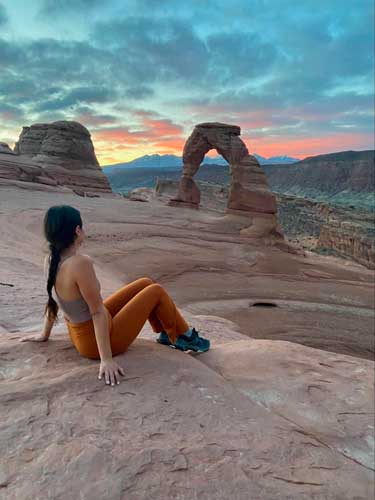 The author sitting in front of the Delicate Arch during sunrise