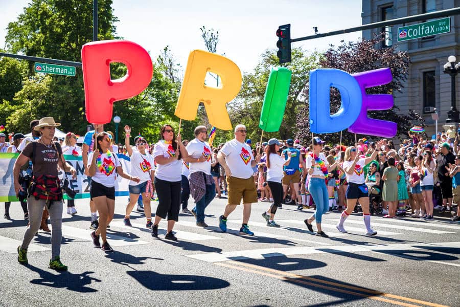 View of people with huge colorful PRIDE letterings during the Denver PrideFest Parade