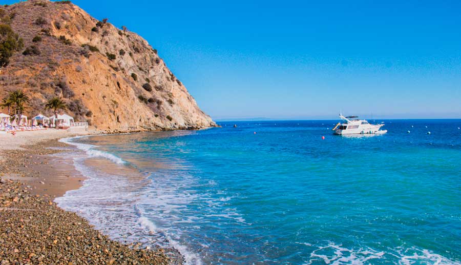 View of a boat in the blue water of Descanso Beach