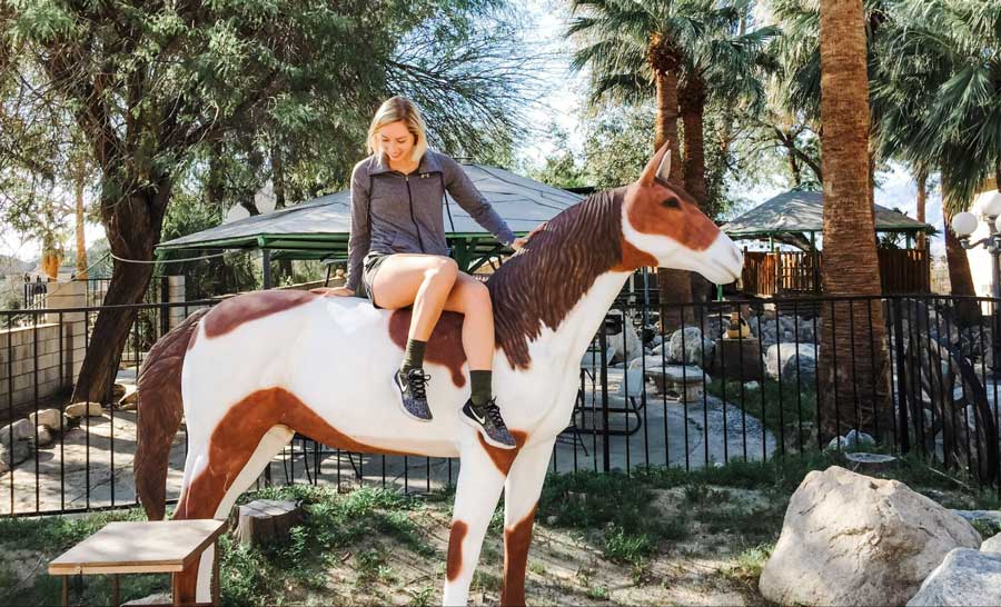 The author riding a horse statue in Desert Hot Springs