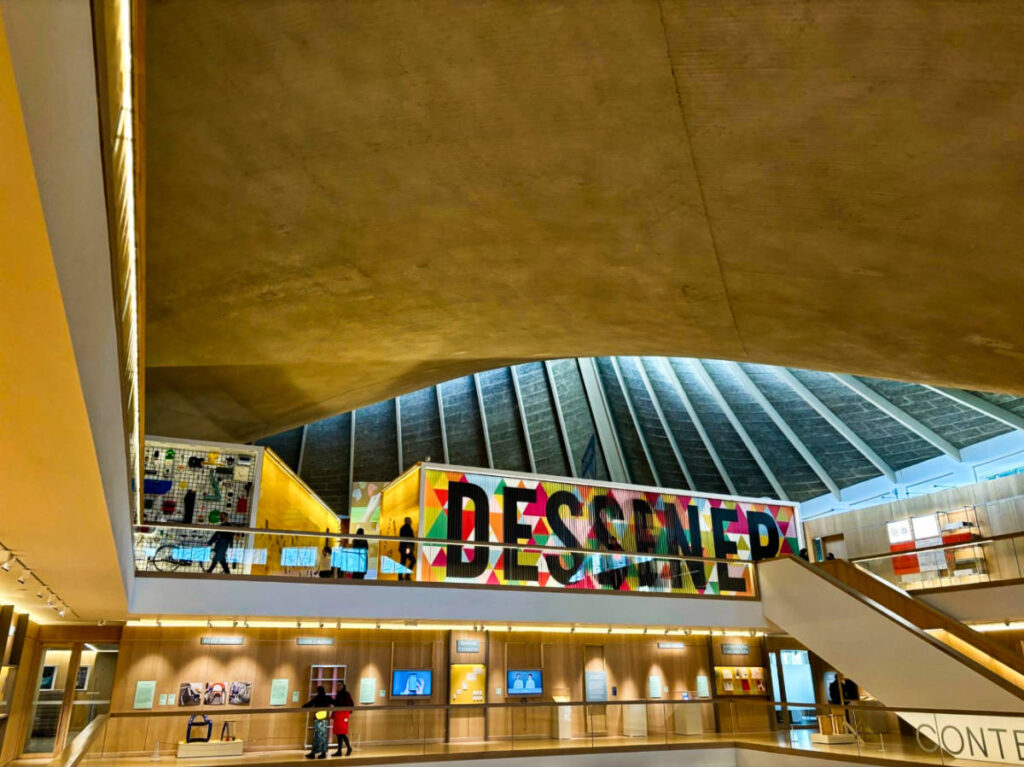View of the iconic colorful sign and the bent concrete ceiling inside the Design Museum