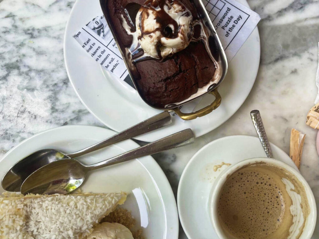 A plate of desserts and a cup of coffee at La Dolcerie