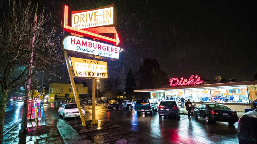 View of the Dick's Drive-In signage from the street on a rainy night
