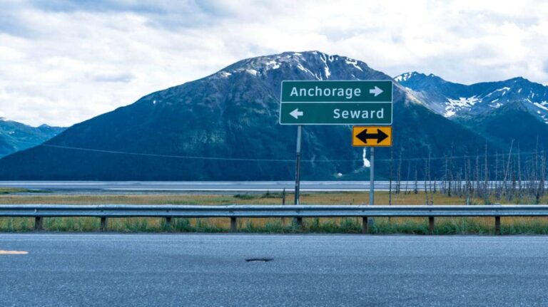 View of the directions to Anchorage and Seward road sign on Alaska highway with mountain views