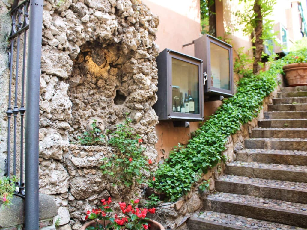 View of the staircase with displayed wine bottles on the side in Bellagio