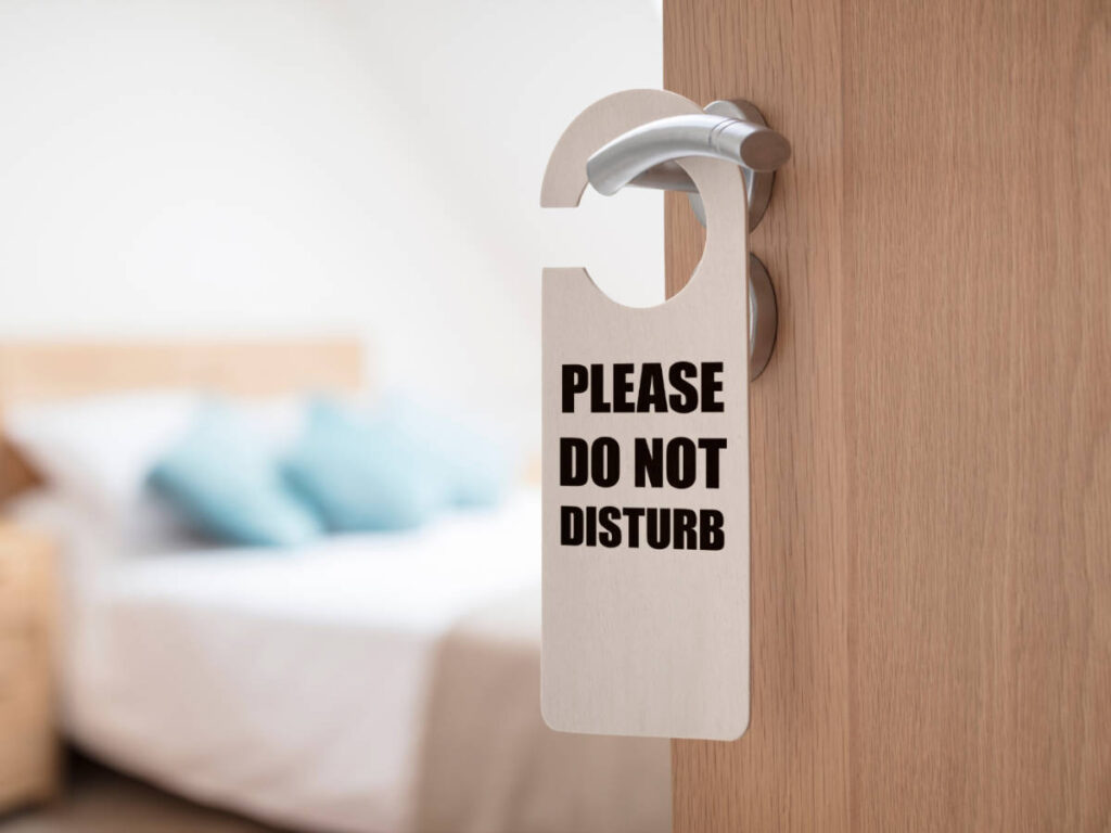 A do not disturb signage hanging on a door knob on a hotel