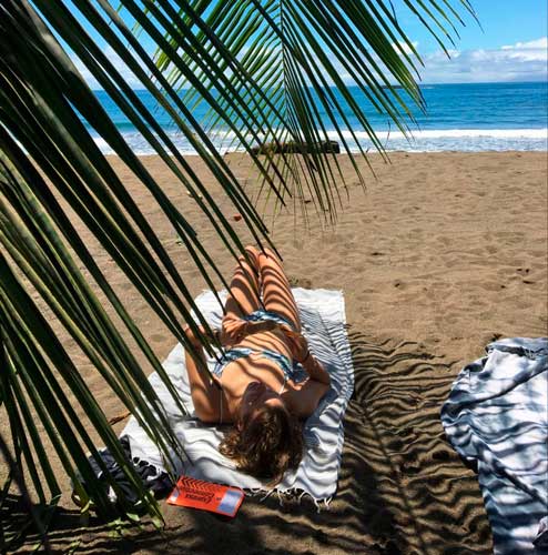 The author laying on the sand of Dominical Beach