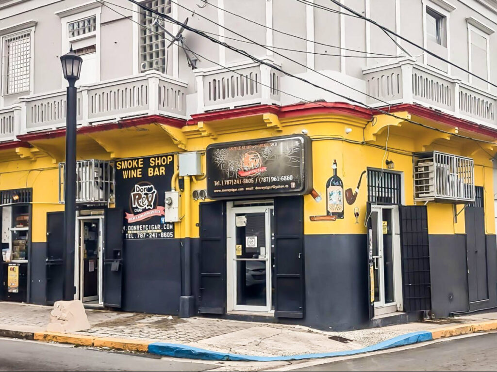 View of the black and yellow exterior of Don Rey Cigars on the corner of the street