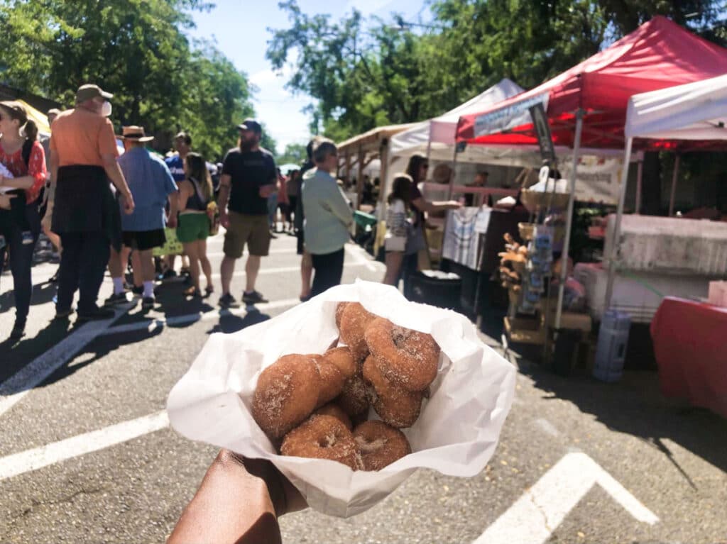 A bag of donuts from Ballard Farmers Market with the crowd in the background