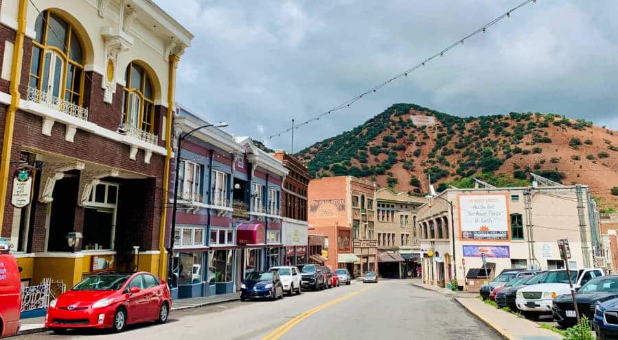 View of the downtown Bisbee full of shops and parked cars beneath ‘B’ Mountain.