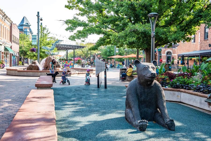 View of the sitting bear statue on the sidewalk of Downtown Fort Collins