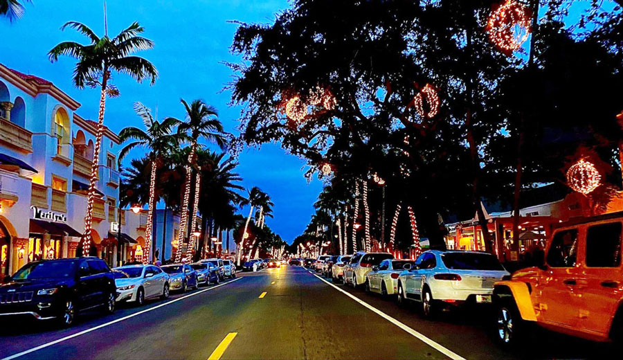 View of Downtown Naples at night with cars parked alongside the road