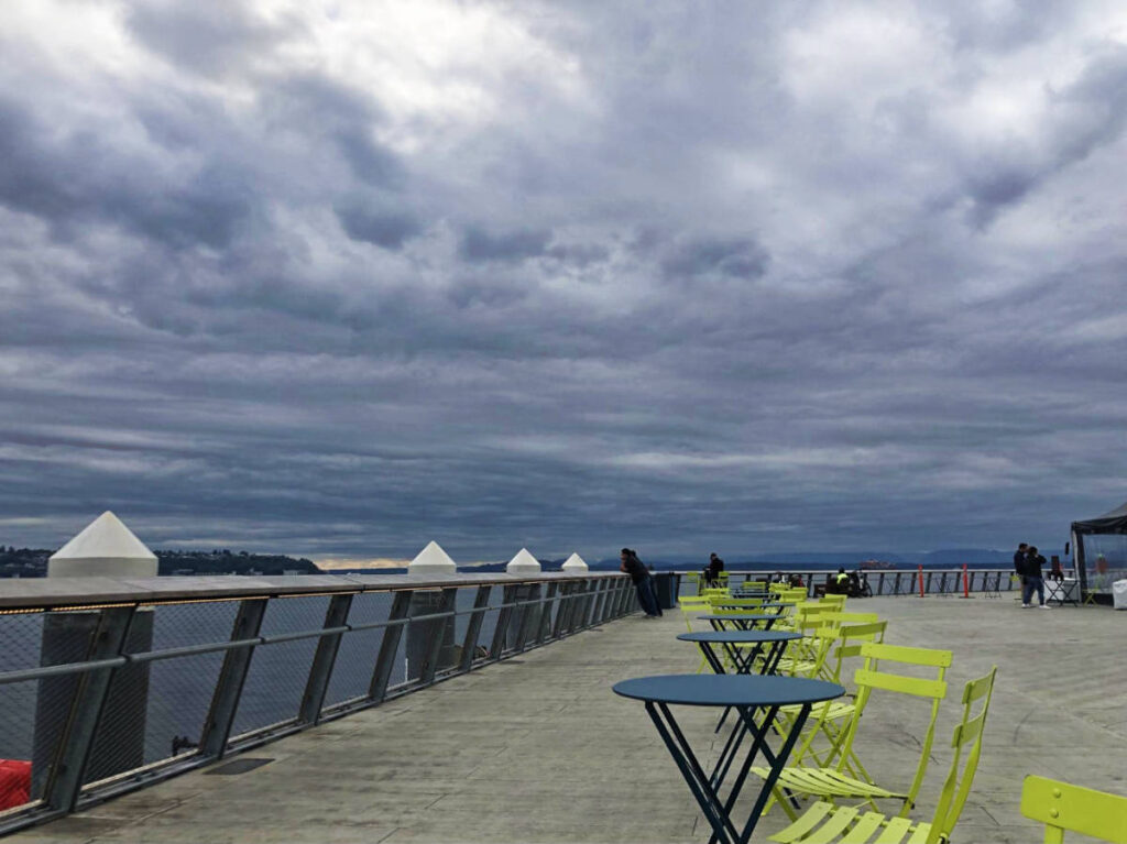 Dark sky over the chairs and tables at the downtown Seattle waterfront