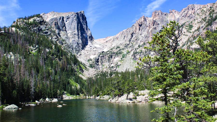 View of the lake with the rocky mountain in the background surrounded by greenery