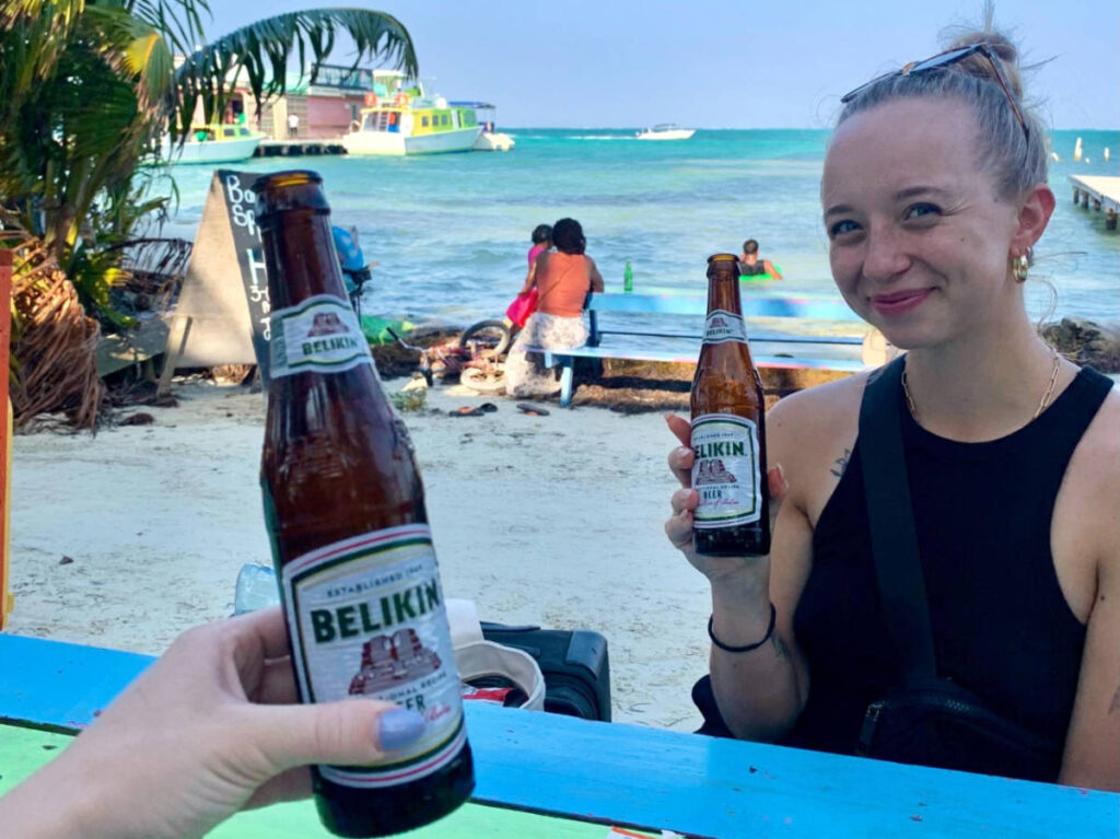 The author Betty Hurd and her friend drinking Belikin Beer at the beach