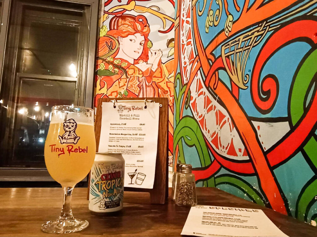 A glass of drink at the colorful interior of Tiny Rebel