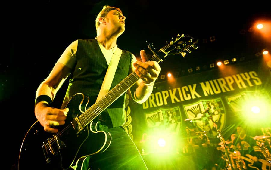 Dropkick Murphys playing the guitar and performing on stage
