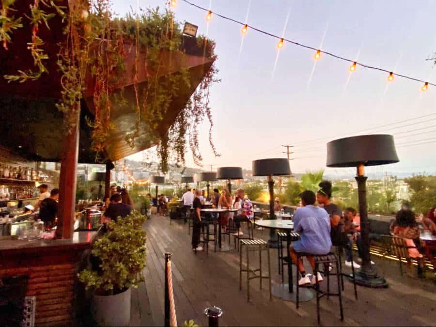 People dining at the rooftop restaurant of E.P. & L.P. during dusk