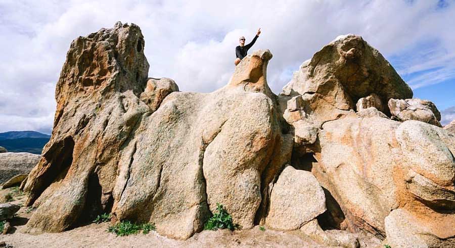 View of a man pointing to the sky on the top of Eagle Rock