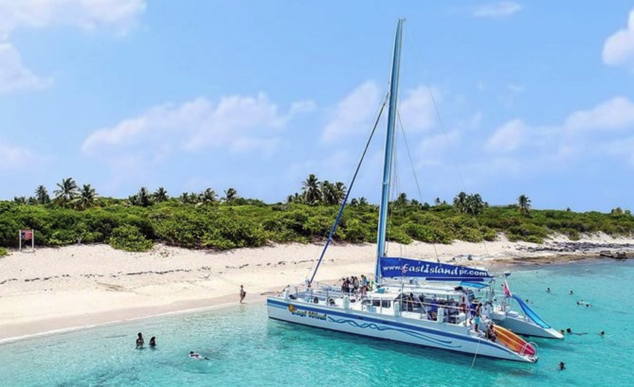 East Island boat docked near the shore with tourists swimming around