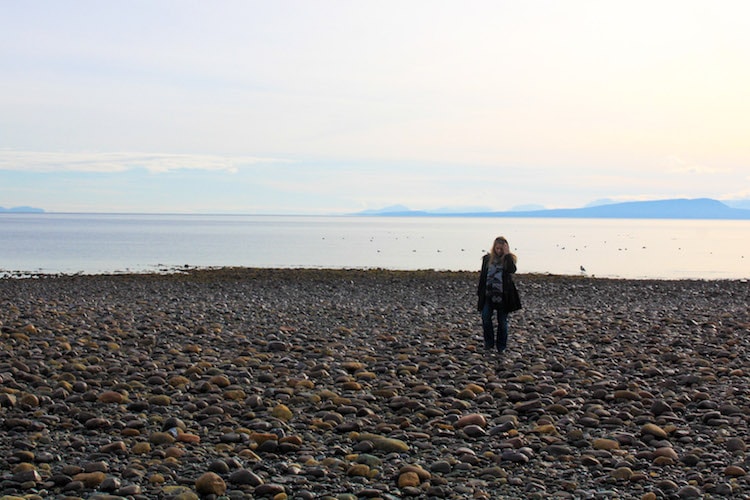 Taylor walks along the pebby beach of eastern Vancouver Island