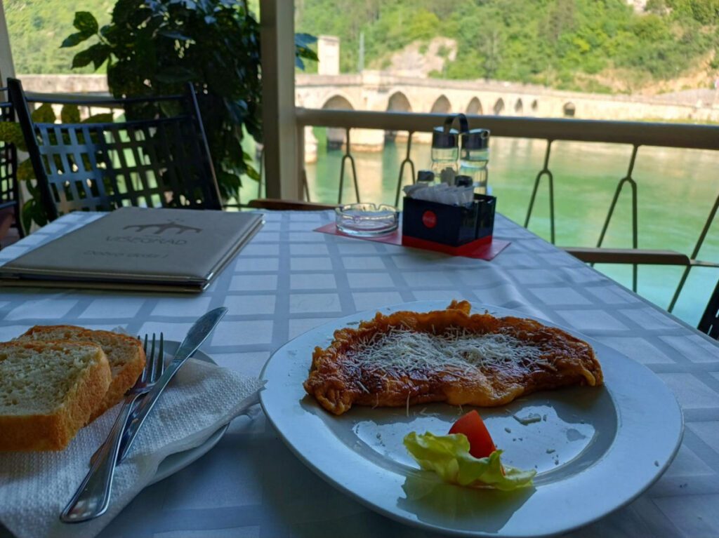 A Plate of food on table with a river view