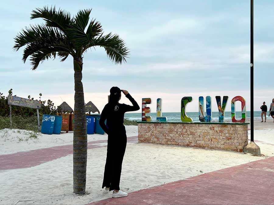 Clara posing for a photo in the El Cuyo sign