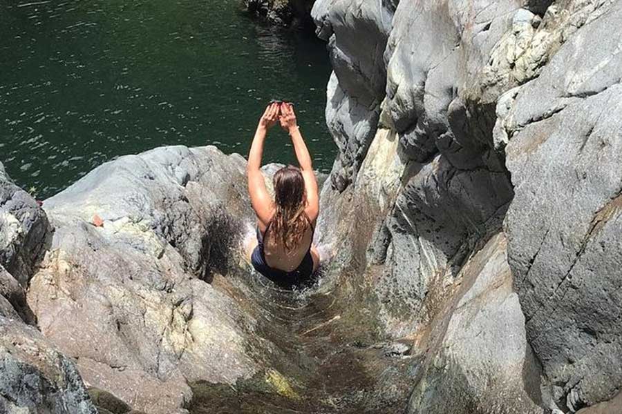 A woman enjoying the natural waterslide in El Yunque