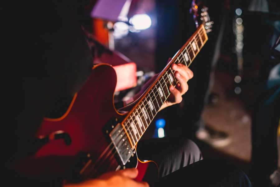 Close up view of the hands playing the electric guitar