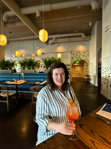The author Elizabeth Demolat, holding a glass of non-alcoholic quasi spritz