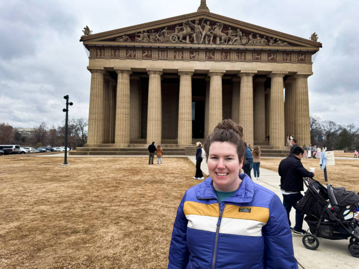 The author Elizabeth, smiling for a photo outside the Parthenon
