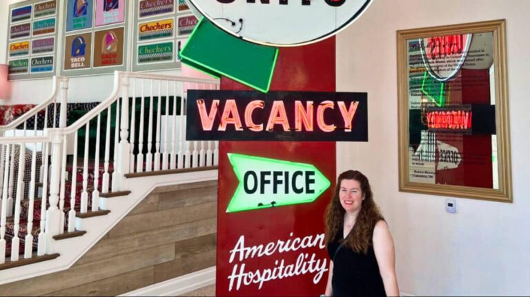 The author Elizabeth Demolat posing near the signages in the lobby of The Graduate Nashville Hotel