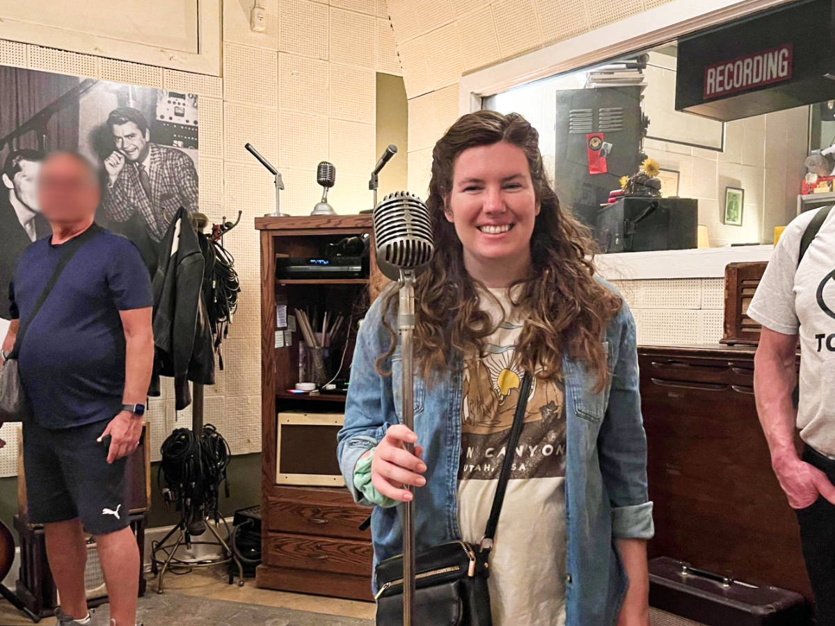 The author Elizabeth Demolat, holding a vintage stand microphone at Sun Studio in Memphis