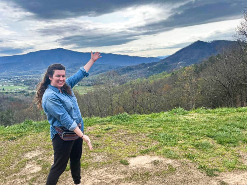 The author Elizabeth Demolat, posing at the Foothills Parkway with the mountain views in the background