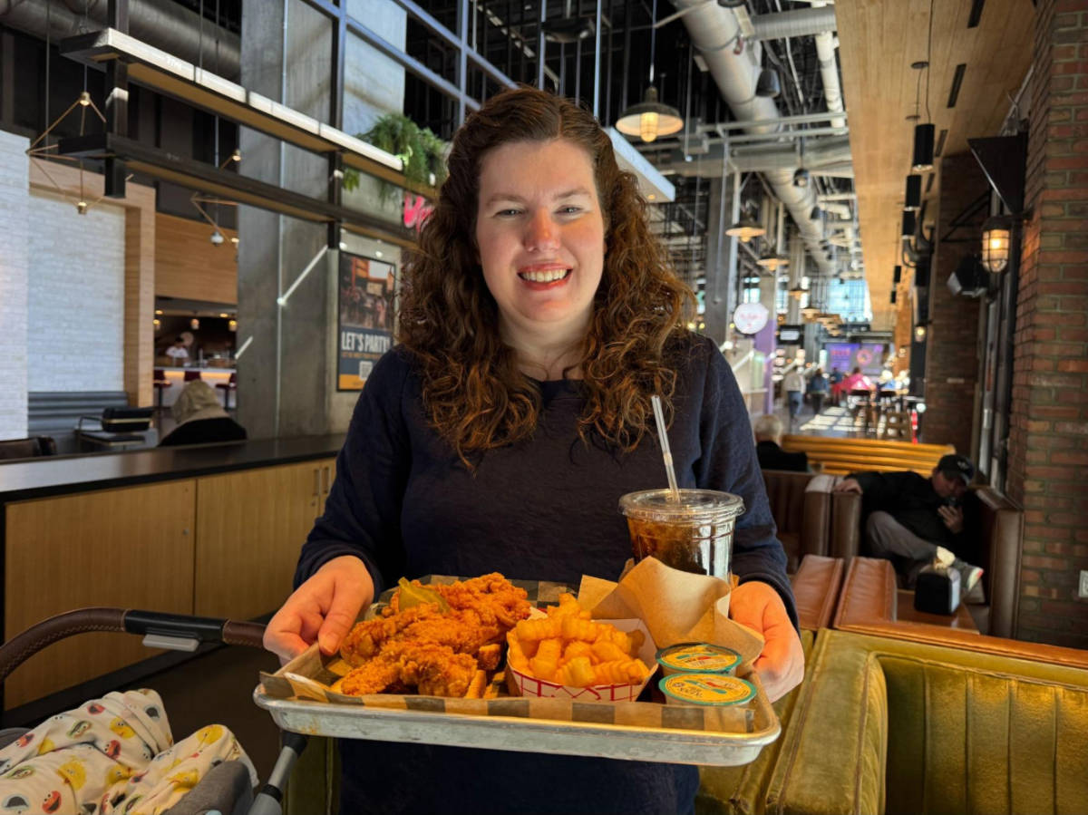 The author Elizabeth holding the Prince’s Hot Chicken food tray at the Assembly Food Hall