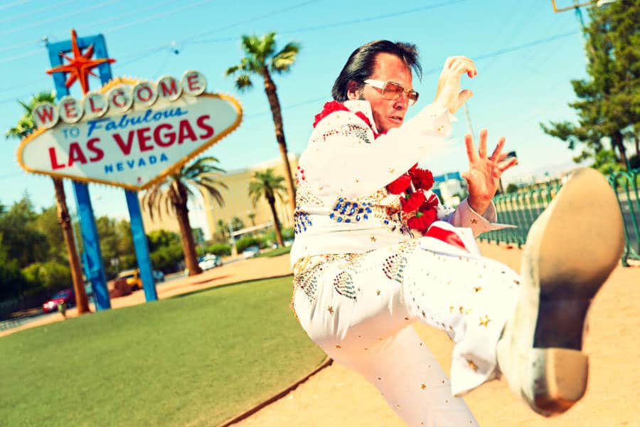 The impersonator of Elvis Presley posing near the iconic Las Vegas sign