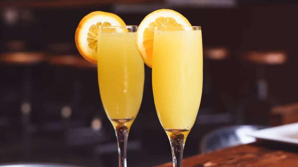 Two glasses of mimosa on a bar counter in Elysian Cafe