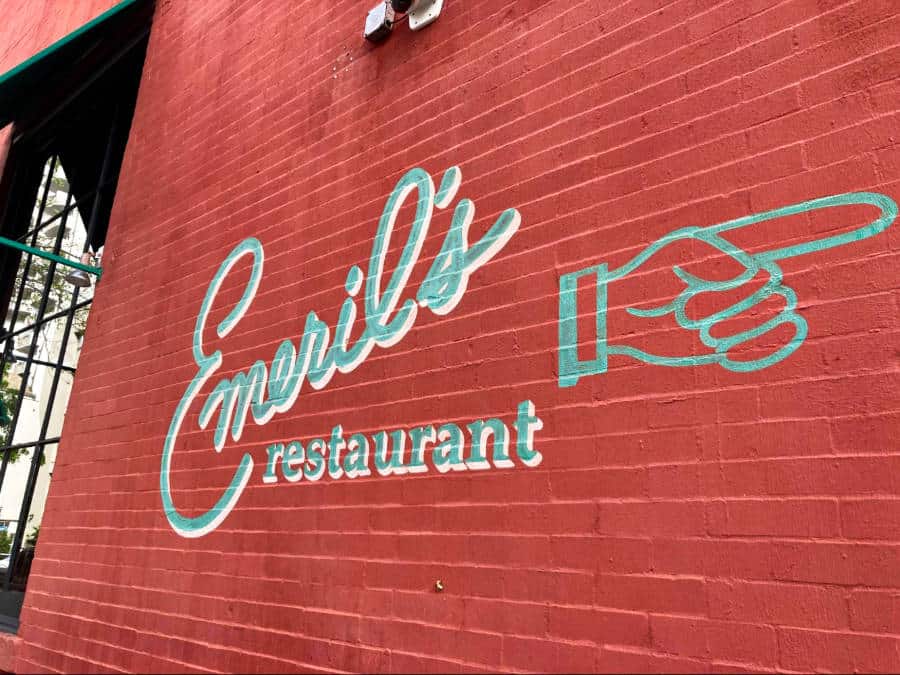 View of the Emeril’s Restaurant signage on a red brick wall