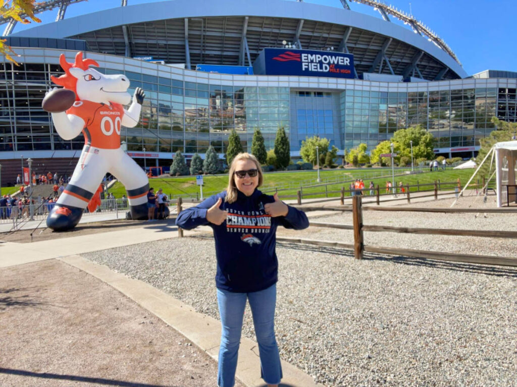 Author Laura Falin at the entrance of Empower Field Denver