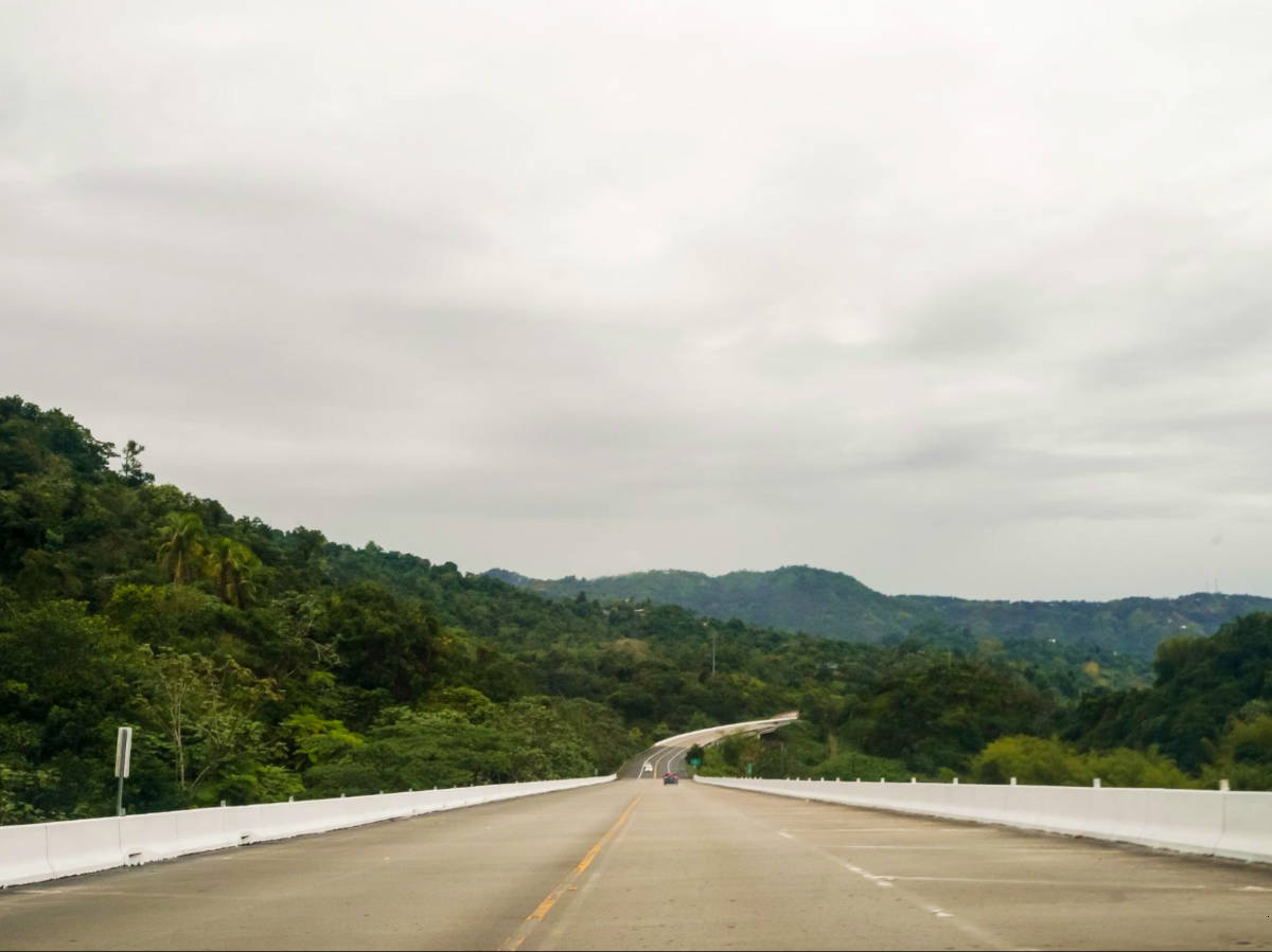 View of a not so busy highway surrounded by greenery in Adjuntas