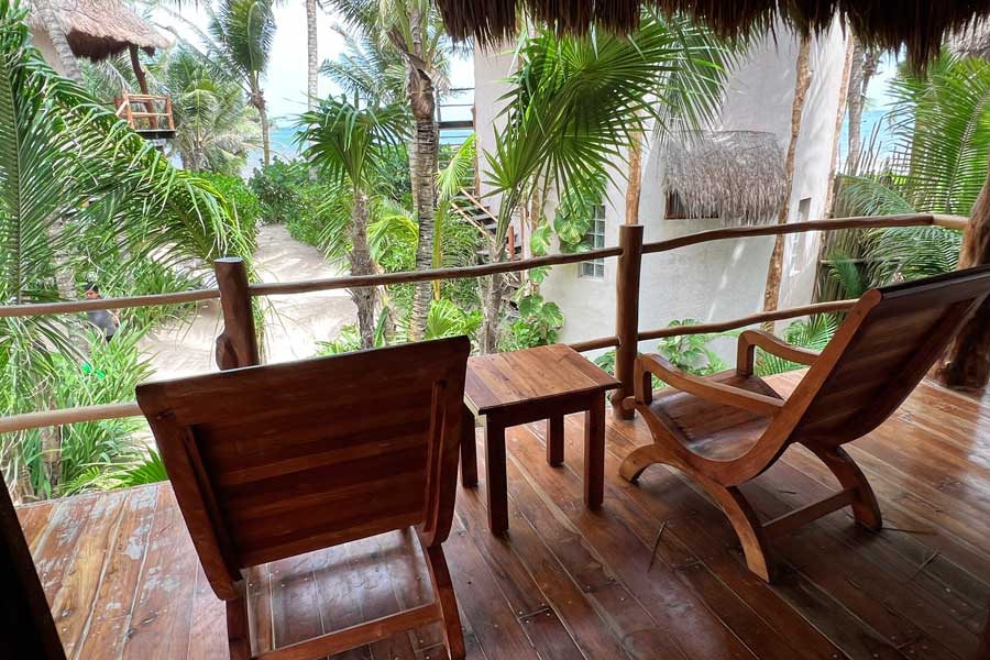 View of chairs and a small table on a balcony in Encantada Tulum