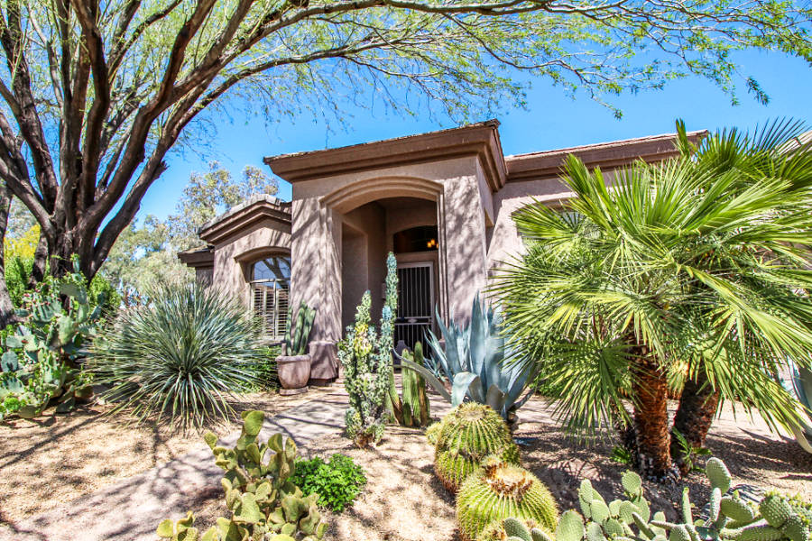 Façade of a southwestern-style home with desert plants around