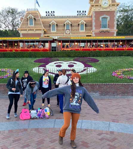 The author posing for a photo at the main entrance of Disneyland