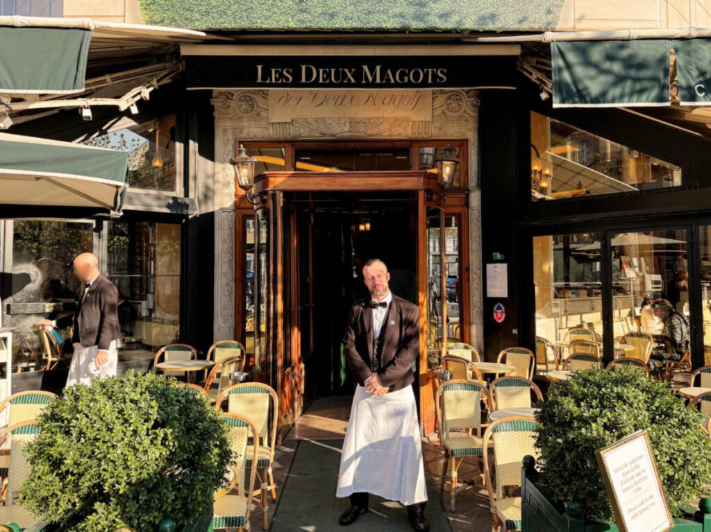 A server at the entrance of the Les Deux Magots