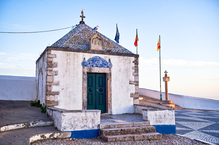 A small chapel with flags and blue tiles around