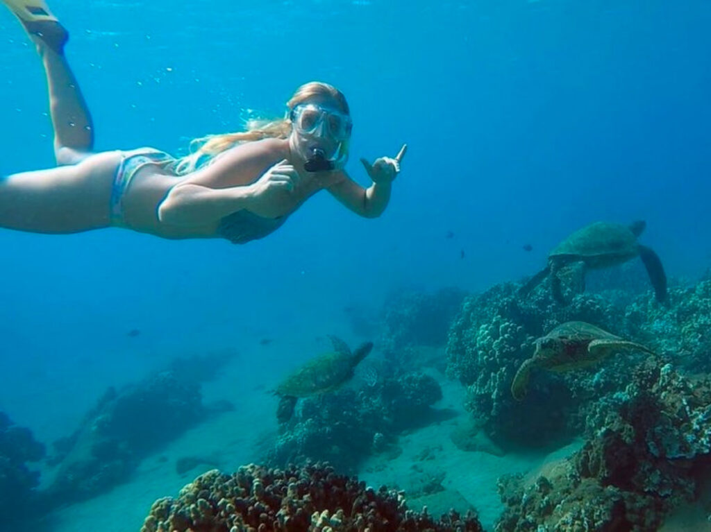 A woman swimming with turtles at Escambrón Beach