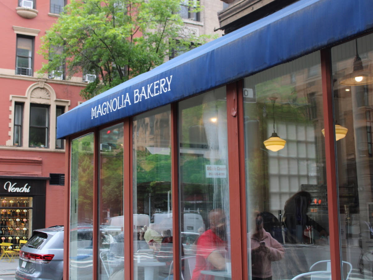 View of the glass walled Magnolia Bakery seen from the outside